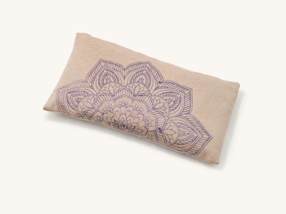 Almohadita de tela cruda con un mandala lila estampado.