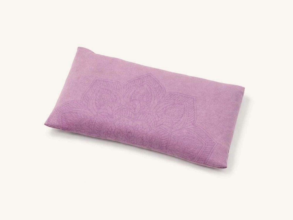 Almohadita de tela rosa con un mandala grabado.